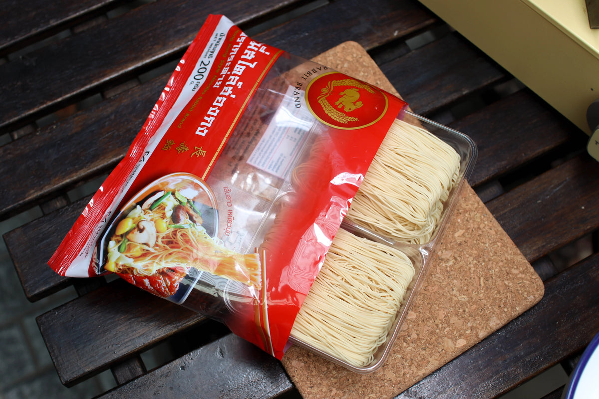 Dry Hong Kong Style Noodles by Rabbit Brand, 200g package, showing uncooked noodles in a clear plastic bag.