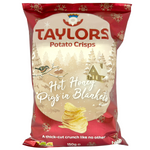 Taylors Hot Honey Pigs in Blankets Crisps, savory confectionery snacks with spicy honey flavor, shown in a colorful bag.