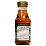 Tate & Lyle Golden Syrup pouring in a clear glass jar, showcasing its rich golden color and smooth texture.