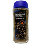 Sainsbury's Gold Roast Decaf Instant Coffee drink in a cup with a spoon and coffee beans beside it.