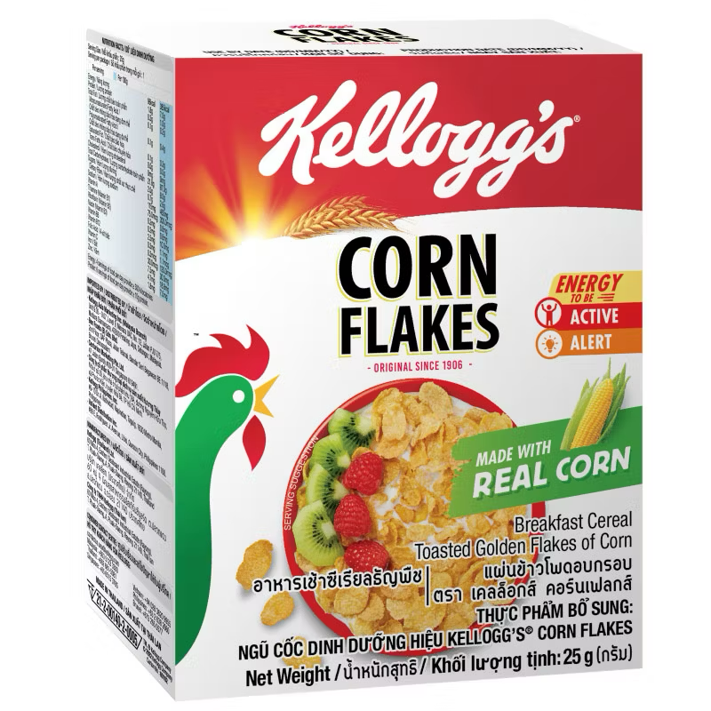 Kellogg's Corn Flakes cereal box with golden flakes and red branding, displayed on a kitchen countertop.