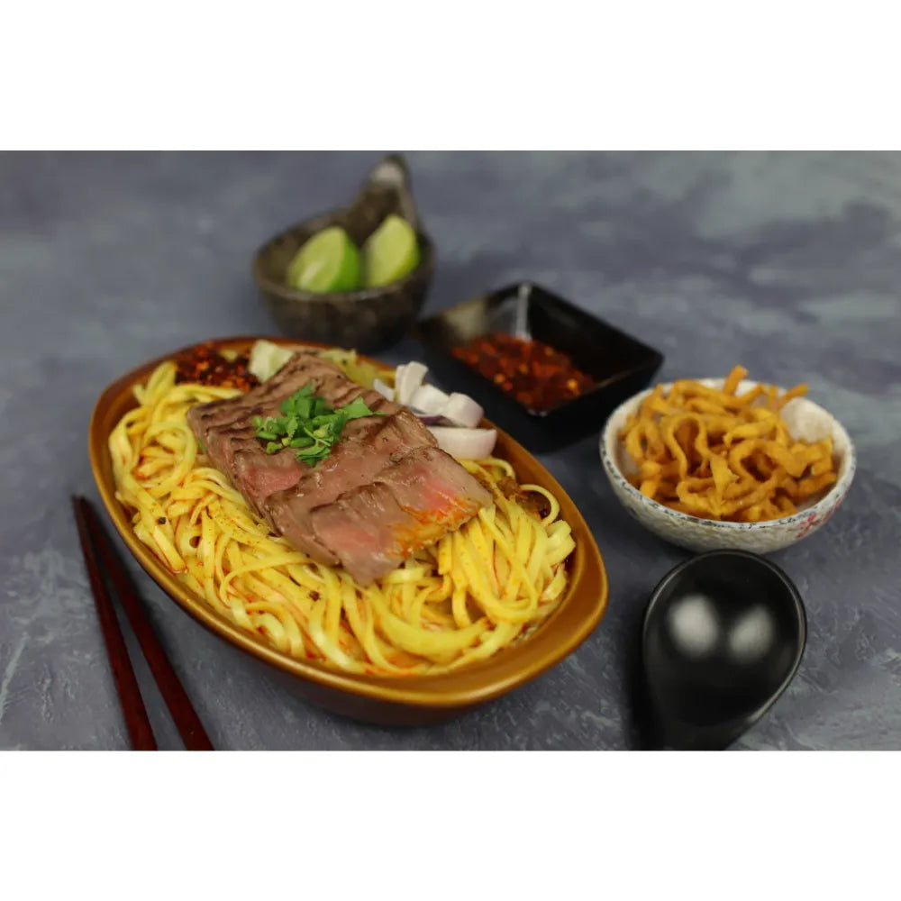 Rabbit Brand Khao Soi noodles 200g, dry grocery product with packaged Thai-style curry noodles and spices in a sealed bag.
