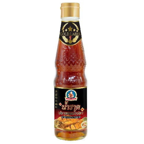 Deksomboon Fish Sauce 300ml bottle, traditional Thai seasoning for cooking, in clear glass with label, on a kitchen counter