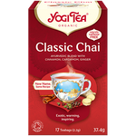 Yogi Classic Blend Tea in a glass mug showing warm herbal tea with tea bag and fresh herbs, promoting relaxation and wellness.