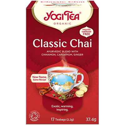 Yogi Classic Blend Tea in a glass mug showing warm herbal tea with tea bag and fresh herbs, promoting relaxation and wellness.