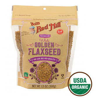 Golden organic flaxseeds in a clear container, showcasing Bob's Red Mill brand on a white background for healthy grocery shopping.