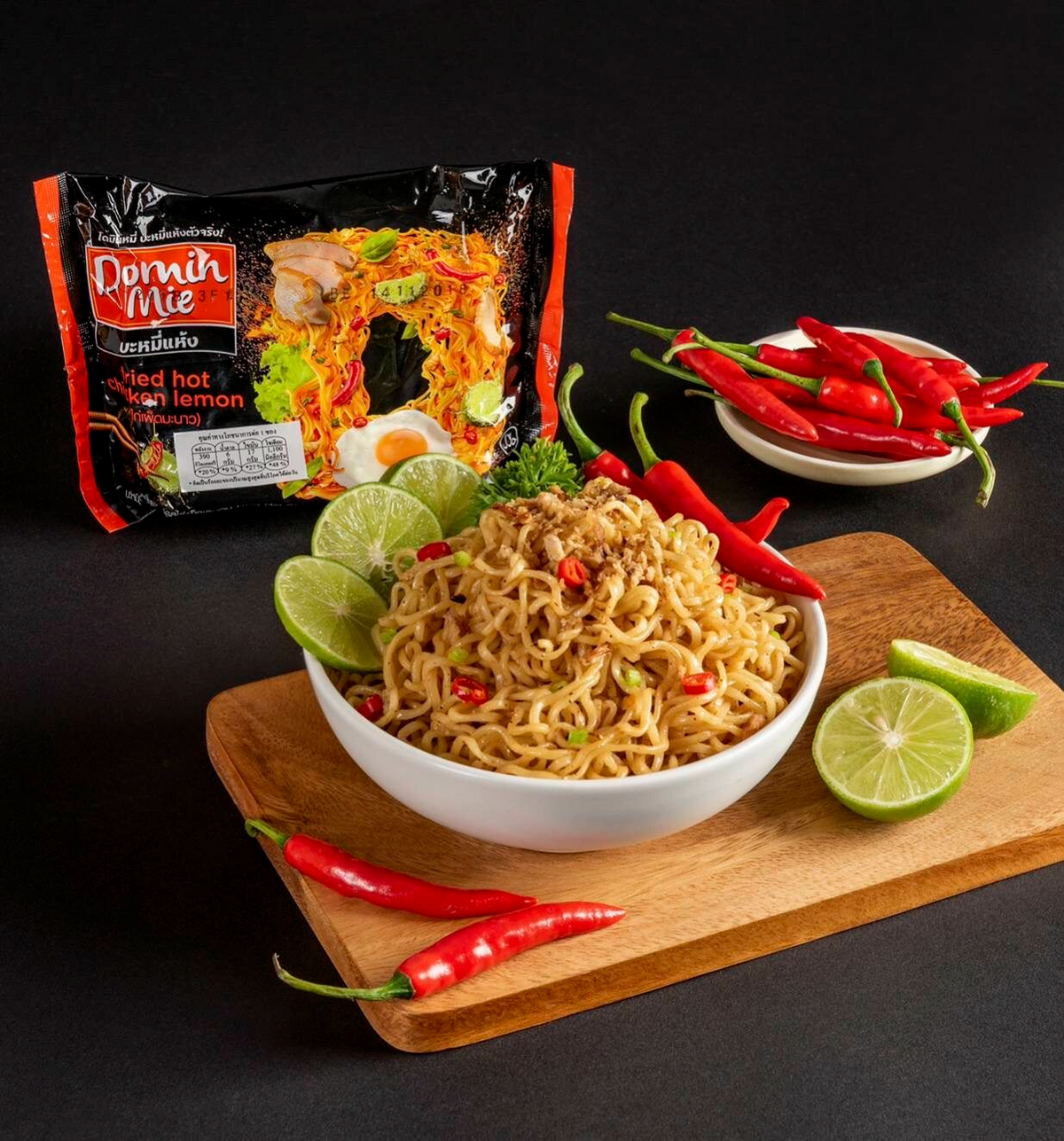 Package of Domin Mie Fried Instant Noodles Hot Chicken Lemon flavor, with noodles and seasoning packet visible.