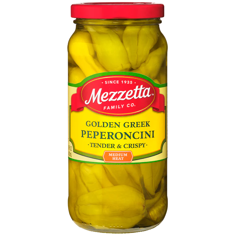 Jar of Mezzetta Golden Greek Peperoncini peppers in a glass container, showcasing vibrant yellow-green peppers on a grocery shelf.