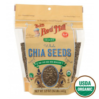 Close-up of Bob's Red Mill Organic Chia Seeds in a clear glass jar, highlighting the small, black and white seeds on a white background.