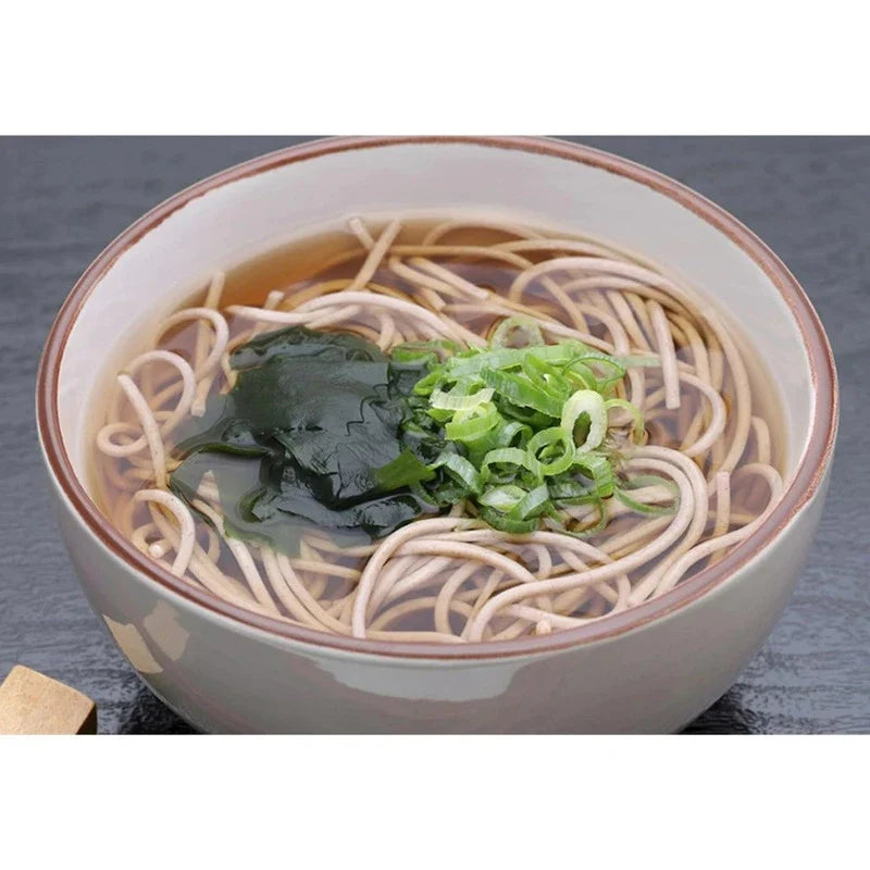Somi Soba Tsuyu Soup with Honjozo Soy Sauce in a bowl, featuring dark soy sauce, soba noodles, and green garnishes.