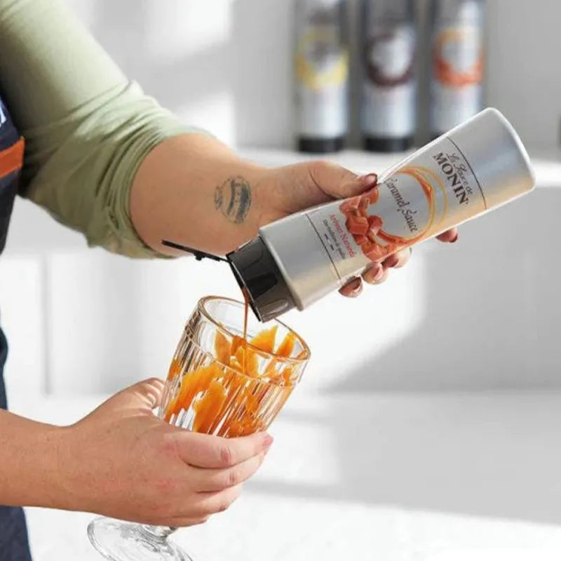 Bottle of MONIN caramel sauce in 500ml size, ideal for desserts and beverages, with a rich, golden caramel color.