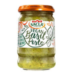 Jar of Sacla Vegan Basil Pesto with fresh basil leaves and garlic on a white background, ideal for pasta and sandwiches.