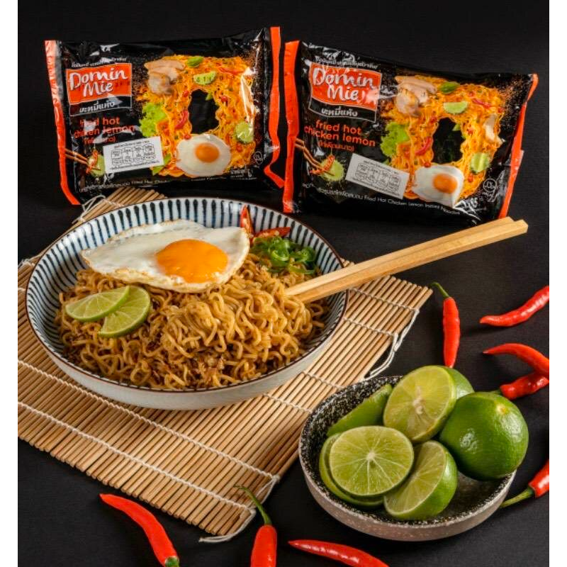 Pack of Domin Mie Fried Instant Noodles Hot Chicken Lemon flavor in a grocery store setting.
