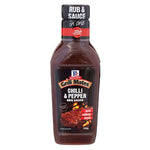 Bottle of McCormick Chilli & Pepper BBQ Sauce, with label showing red chili peppers and black peppercorns on a grocery shelf.
