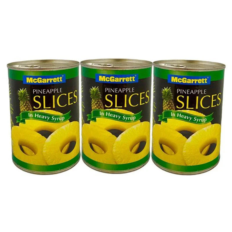 Canned Mcgarrett pineapple slices in heavy syrup, 565g x3, showing shiny pineapple rings in syrup in a transparent can