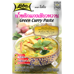 Lobo Green Curry Paste in a jar, ready for cooking, with fresh green herbs and spices visible around it.