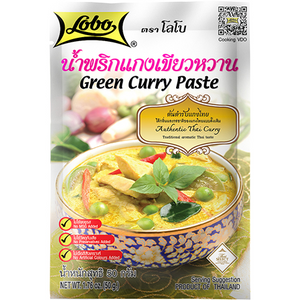 Lobo Green Curry Paste in a jar, ready for cooking, with fresh green herbs and spices visible around it.