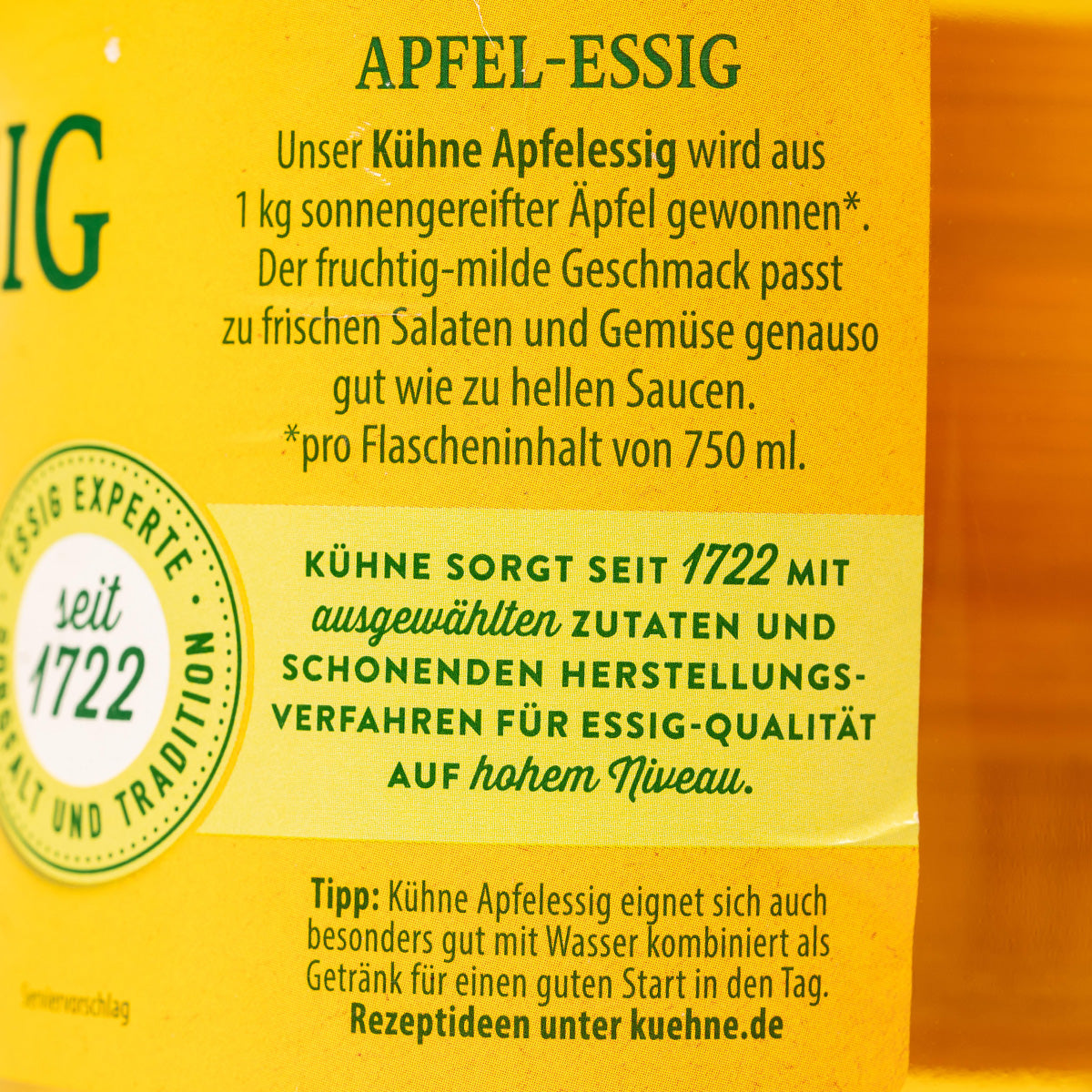 Kuhne Apple Cider Vinegar in a clear glass bottle, showcasing its golden liquid and label with brand and product details.