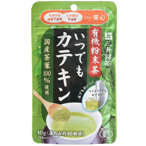 Nittoh Organic Tea Powder drink in a clear glass cup, showcasing vibrant green tea with a frothy top and fresh tea leaves nearby.