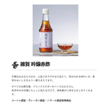 Kokonoe Saika Ginjosu Red Rice Vinegar 1.8L bottle in a clear plastic container, showcasing the label and red rice vinegar inside.