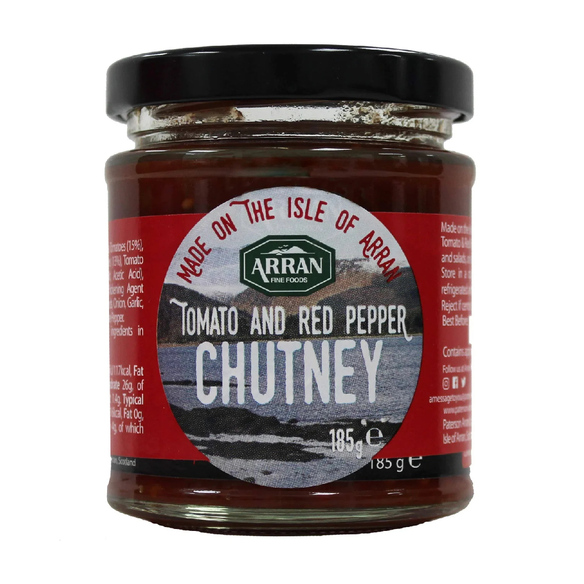 Jar of Arran Tomato and Red Pepper Chutney with fresh red peppers and ripe tomatoes on a wooden surface.