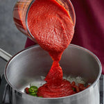 Brook Tomato Puree 550g jar, dry grocery product, with vibrant red tomato puree visible inside the container.