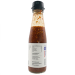 Bottle of Tid Too Thai Jaew Chili Sauce in a clear glass container with a colorful label, ready for cooking or dipping.