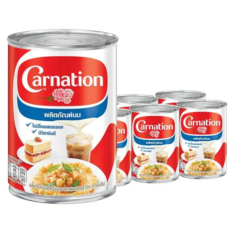 CARNATION evaporated milk 405g cans stacked in a box, ideal for baking and cooking, part of dry grocery essentials.