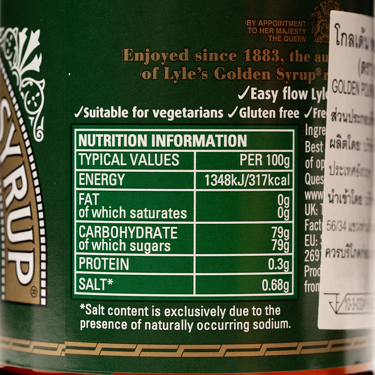 Tate & Lyle Golden Syrup pouring from a bottle into a bowl, showcasing thick, amber syrup for baking and breakfast use.