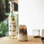 Bottle of MONIN Osmanthus Syrup, 700ml, dry grocery product with a clear label and dark liquid inside.