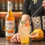 Monin Tropical Island Blend Syrup 700ml bottle with vibrant label, ideal for tropical-flavored beverages and cocktails.