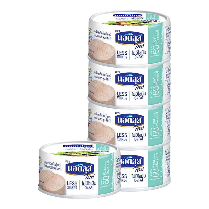 Cans of Nautilus Lite Tuna Steak in spring water, 165g each, stacked in a row for dry grocery shopping.