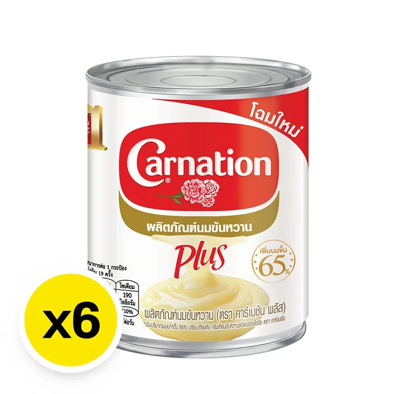 CARNATION Carnation Plus Sweetened Condensed Milk 380g can, stacked in six-pack, in a shopping basket or on store shelf.