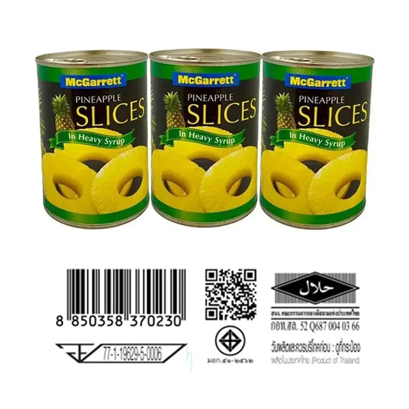 Canned McGarrett pineapple slices in heavy syrup, 565g per can, shown in three cans with labels and pineapple slices visible.
