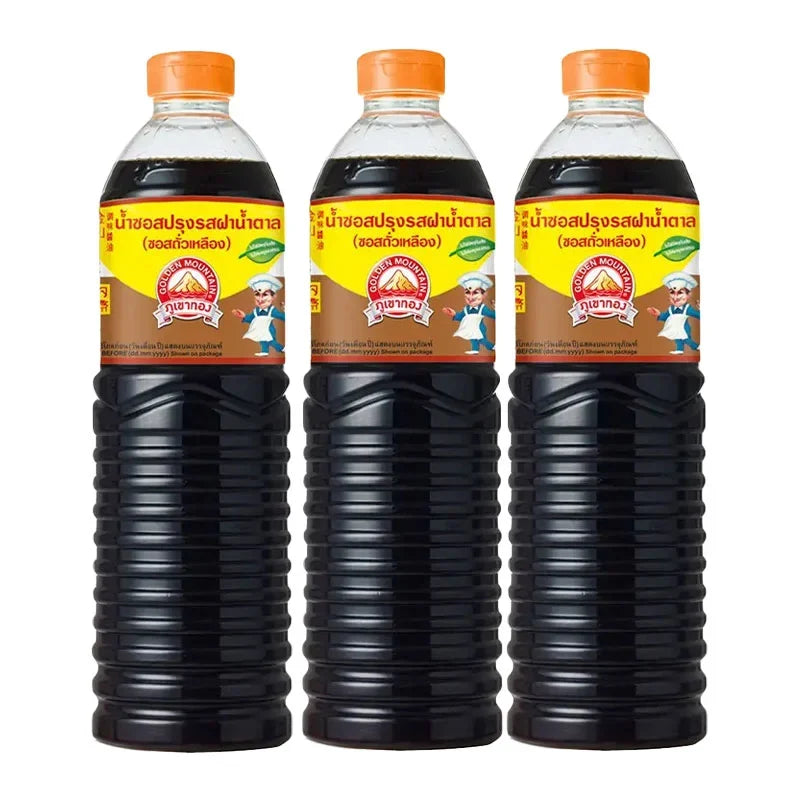 Three 1L bottles of Golden Mountain Sauce Brown, a dry grocery condiment, shown in clear bottles with golden labels.