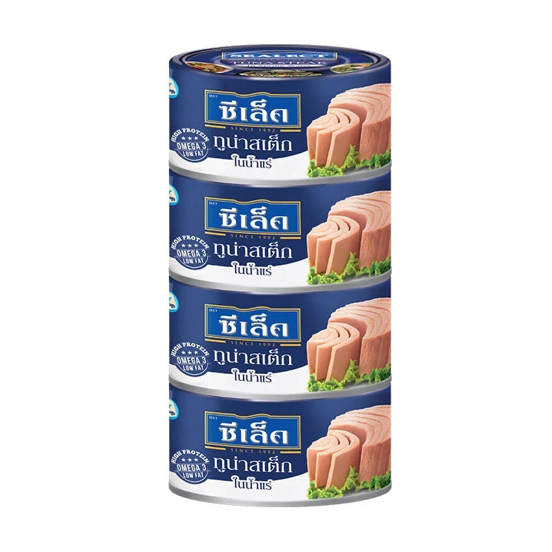 Cans of Sealect Tuna Steak in spring water, 165g x4, arranged on a kitchen counter, showcasing the product packaging.