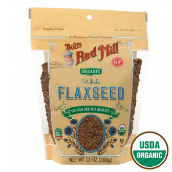 Organic brown flaxseeds in a clear glass jar, displayed as a healthy grocery product from Bob's Red Mill.