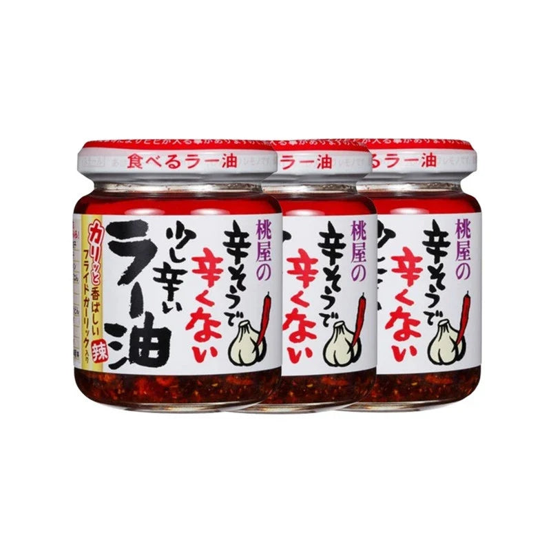 Momoya Taberu Layu Chili Oil with rapeseed and fried garlic in a clear glass bottle, highlighting the ingredients and packaging.