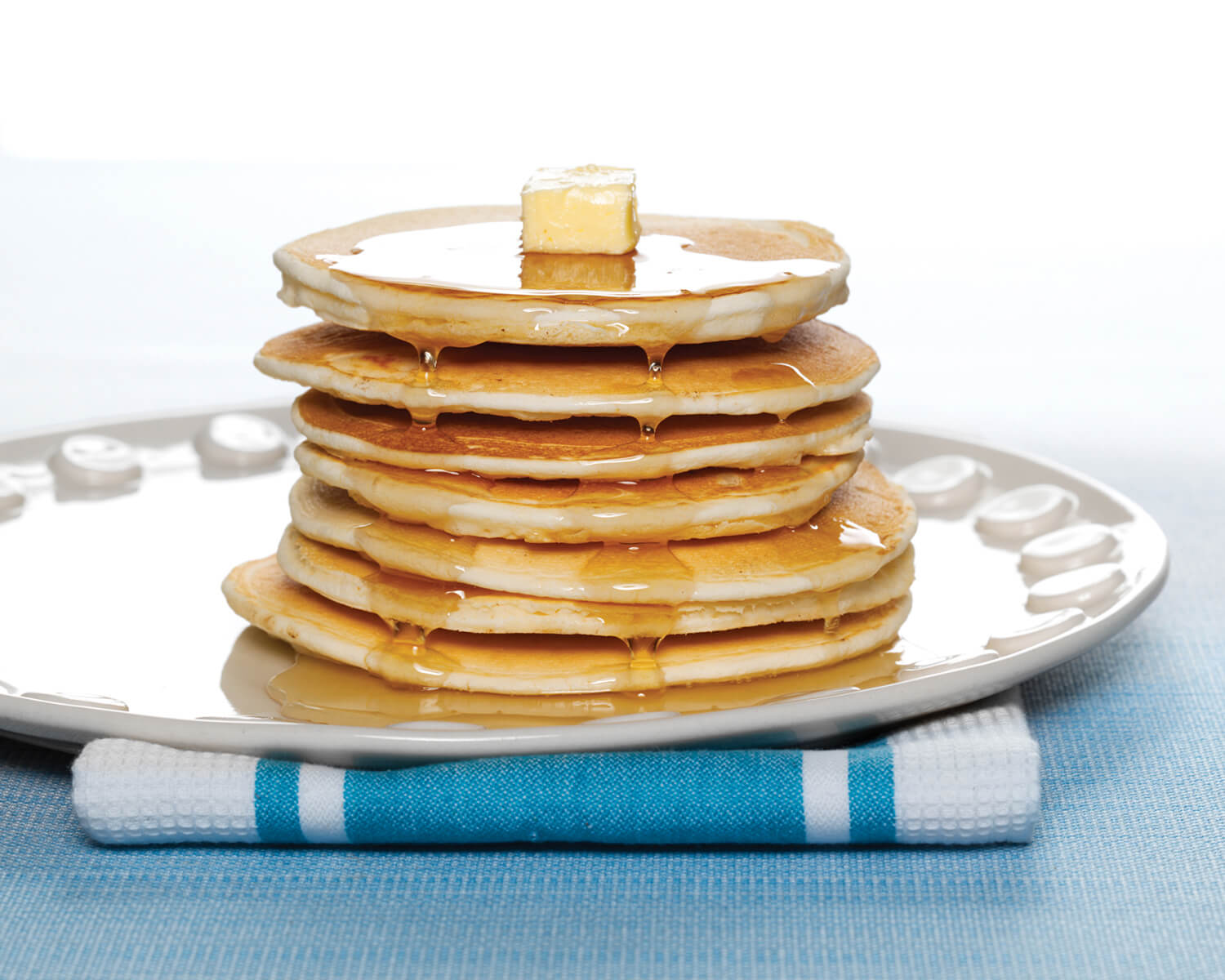 Yes You Can Butter Milk Pancake in a bowl, showing a healthy grocery product with a golden pancake topped with butter and syrup.