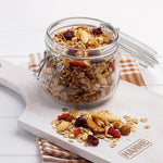Hahne Bircher Muesli 375g box with dry oats, dried fruits, and nuts in a natural setting, ready for breakfast.