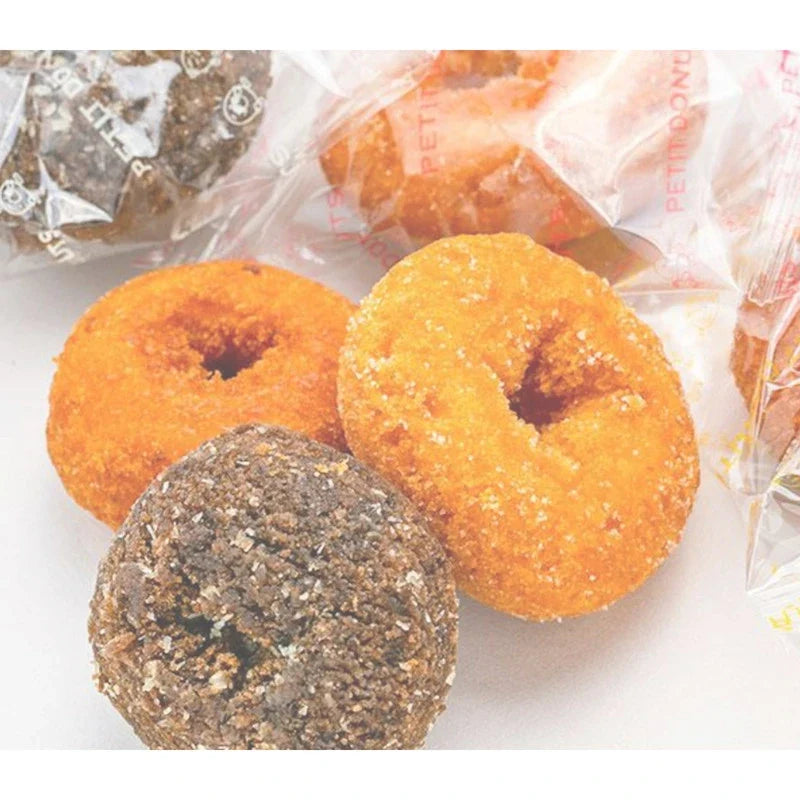 Petite Shinkou bite-sized donuts with assorted flavors, featuring old-fashioned glazed, chocolate, and vanilla varieties in a dry snack package.