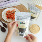 Pure Grain 100% instant roasted white sesame seeds in a 80g pack, ideal for cooking and garnishing in dry grocery recipes.