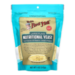 Bob's Red Mill Nutritional Yeast in a clear container, showing yellow flaky nutritional yeast for cooking and seasoning.