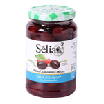 Selia pitted black Kalamata olives in a bowl, showcasing glossy, dark purple olives on a white background for grocery shopping.