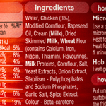 Can of Heinz Cream of Chicken Soup with label visible, placed on a grocery store shelf.