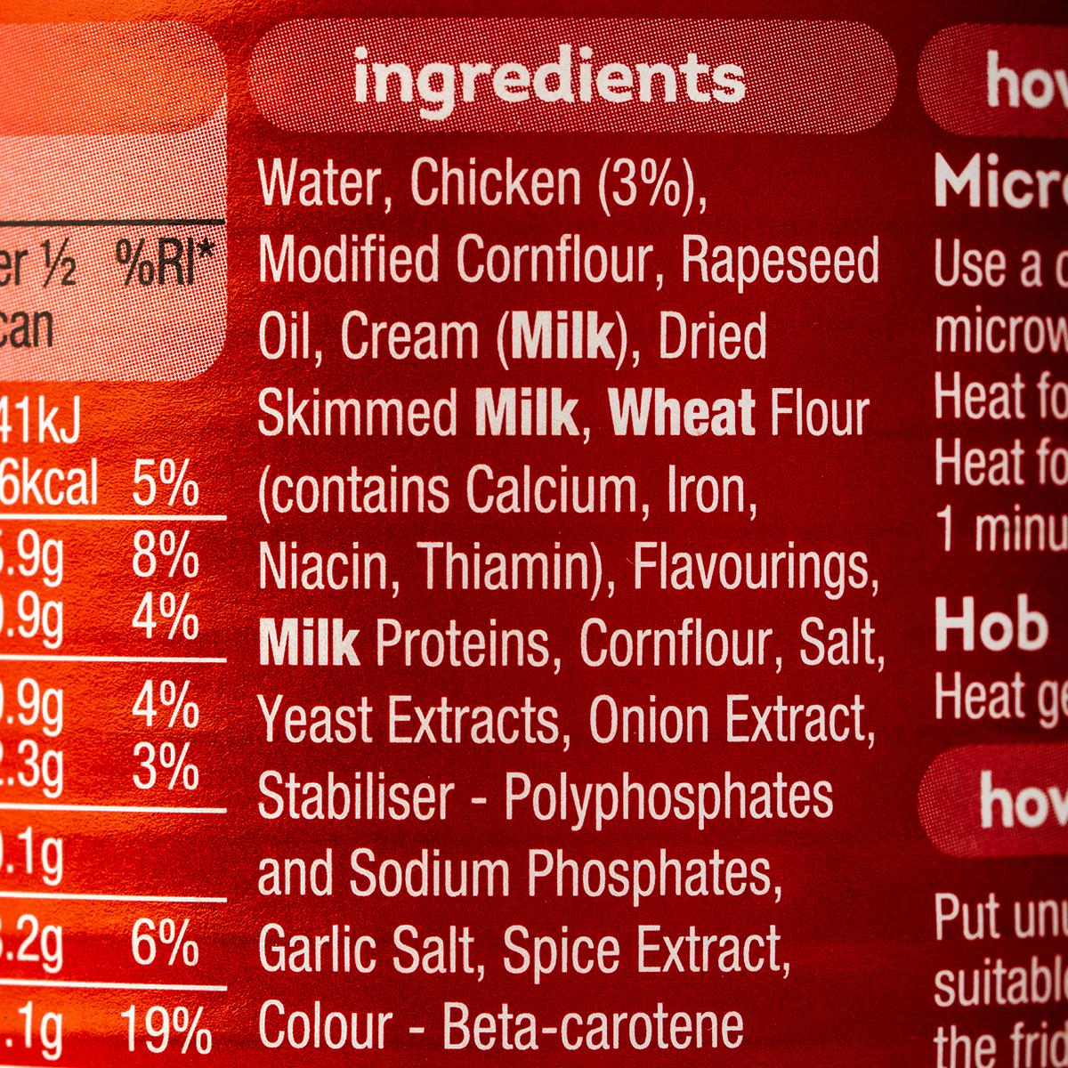 Can of Heinz Cream of Chicken Soup with label visible, placed on a grocery store shelf.