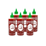 J-lek Sriracha Chili Sauce bottle, spicy formula, 455ml, in clear glass with red chili branding, on a kitchen countertop.