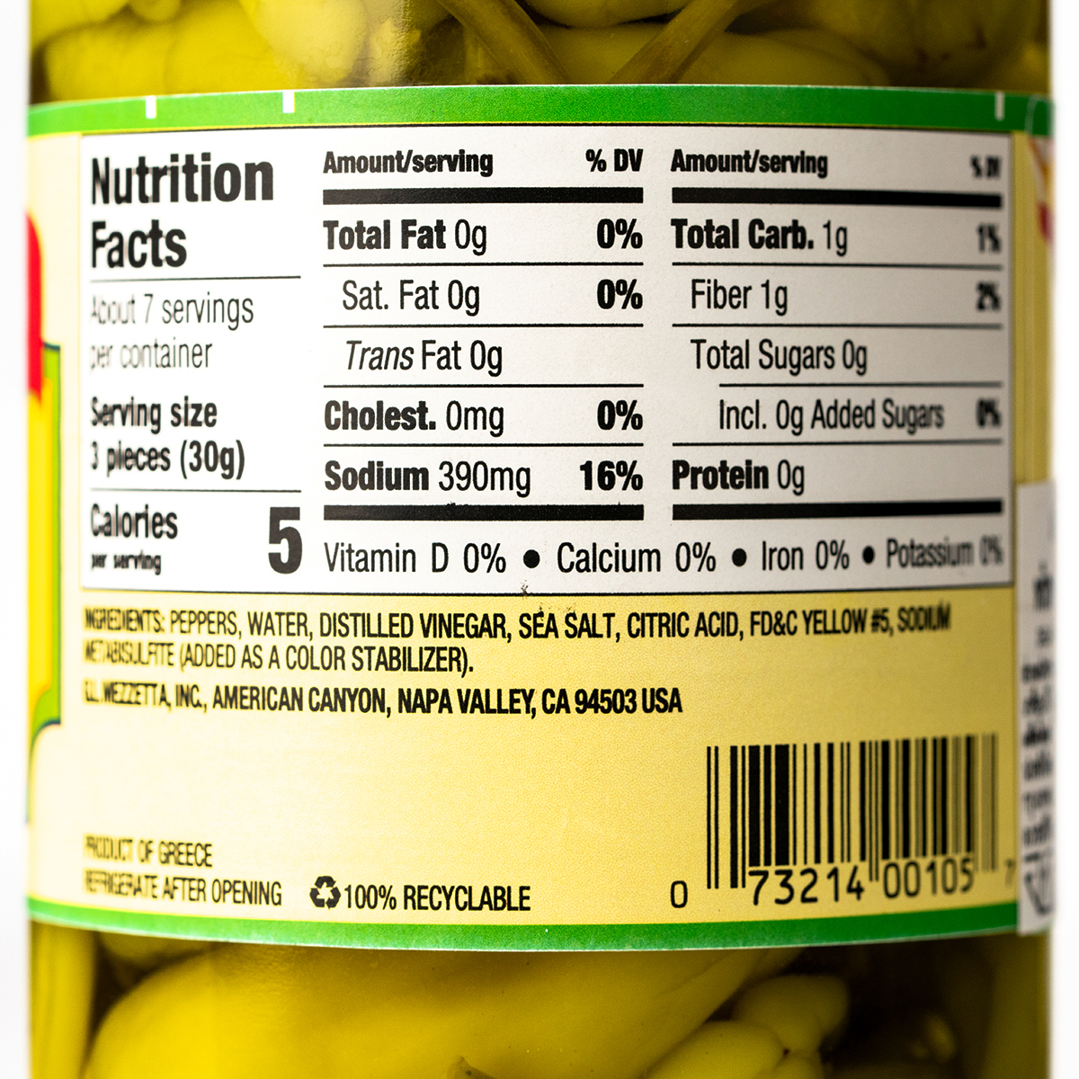 Close-up of a jar of Mezzetta Golden Greek Peperoncini peppers in brine, showcasing vibrant yellow peppers in a glass jar.