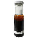 Guyvy Healthy Shoyu Sesame Oil Dressing in a clear glass bottle, showcasing its rich sesame and soy sauce ingredients.