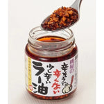 Momoya Taberu Layu chili oil bottle with rapeseed and fried garlic, used as flavoring in Asian cuisine.